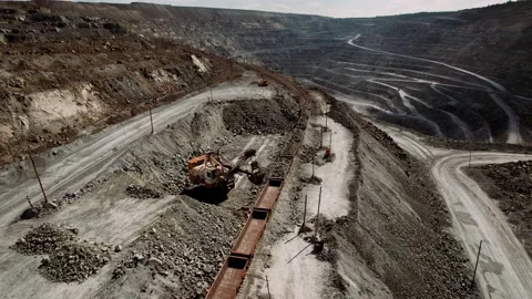Excavator loads iron ore into a freight train. Mining industry concept. Stock Footage 158701080