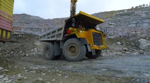 Excavator loads juggernaut in the quarry. Video stock 55355373