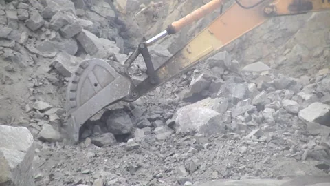 Excavator loads ore into the body of a dump truck in a stone quarry. Video stock 104713888