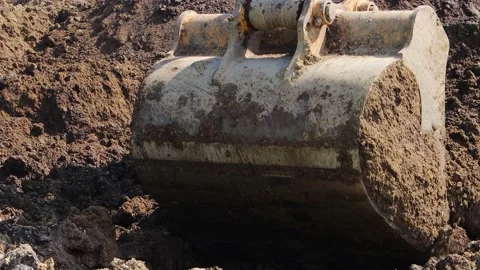 The excavator loads the soil into the bucket. Stock Footage 197626894