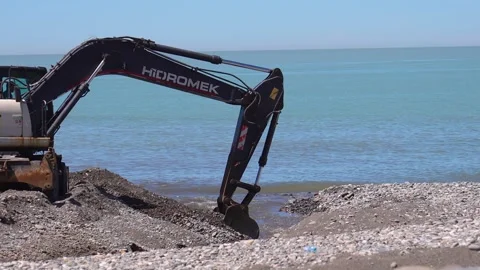 Excavator machine digging sand on a beach construction site Stock Footage 342076525