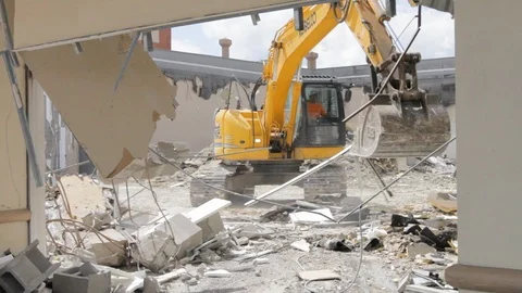 Excavator machine digs up scrap material and metal at destroyed building Stock Footage 125055897