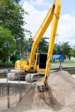 Excavator machine loading soil or sand into truck body Stock Photos