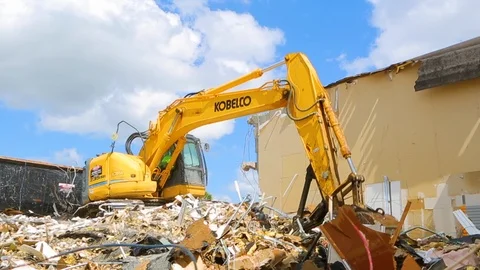 Excavator machine scooping up rubble from building demolition B Video stock 114926359