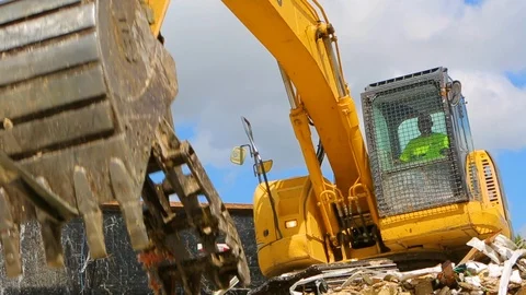 Excavator machine scooping up rubble from building demolition C Stock Footage 114926425