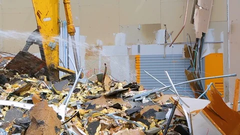Excavator machine scooping up rubble from building demolition CU Video stock 114926575