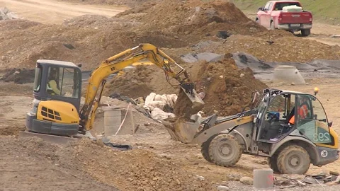 Excavator Machine Unloading Ground and Dumper Truck On Construction Site. Stock Footage 150500004