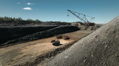 Excavator mining metals in an open pit. Dumptruck and bullzdozer at work. Video stock 205315128