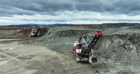 Excavator mining ore in open pit mine under cloudy sky. Stock clip Stock Footage 312072824
