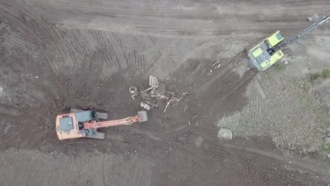 An excavator moves forward on dirt from drone view two excavators dig the ground Stock Footage 169323972