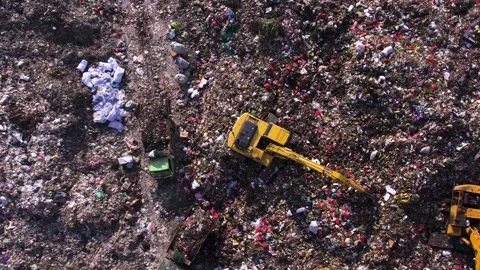 Excavator operating on a dump, surrounded by waste piles. Thrash truck Stock Footage 295953138