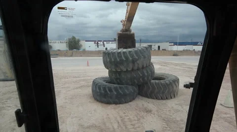 Excavator Picking up Tractor Tire Stock Footage 55380244