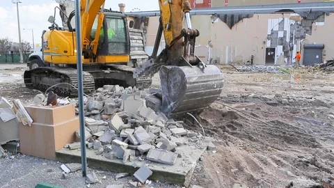 Excavator picks up cinder blocks and drops pieces into dumpster truck B 스톡 동영상 125055841