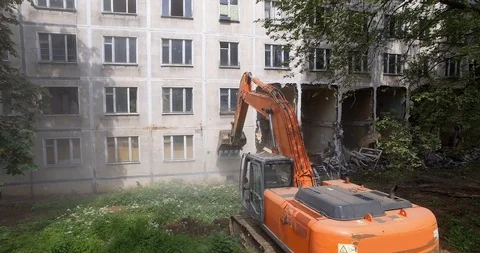 Excavator pulling down old panel apartment house Stock Footage 124624206