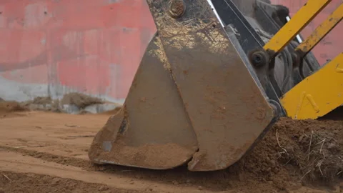 Excavator pulls bucket across soil creating smooth surface Stock Footage 313832300