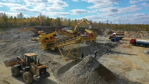 Excavator in quarry loads stone in stone crusher. 4k Aerial Stock Footage 236398218