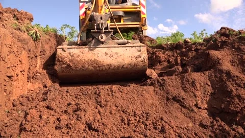 Excavator in red soil field Stock Footage 239724499