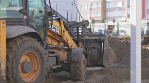 Excavator reverses while leveling remaining soil with wheels Vídeo Stock 306418417