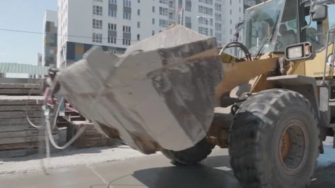 Excavator rides on a construction site with building materials Stock Footage 132492438