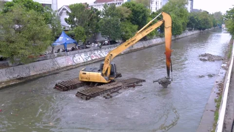 Excavator in a river digging cumulative dirt that shallowing the river Stock Footage 318751124