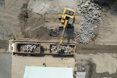 Excavator scooping rocks, stone construction Stock Photos