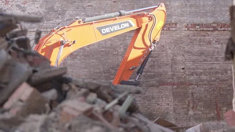 Excavator scoops rubble lifting chunks from uneven ground 動画素材 314648901