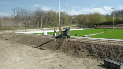 Excavator transferring dirt on a construction site of a Soccer field constructio 스톡 동영상 238974670