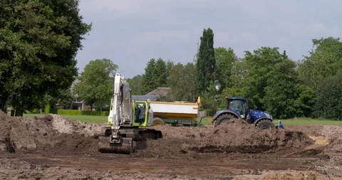 Excavator transporting earth into a tractor and tipping trailer Stock Footage 109549862