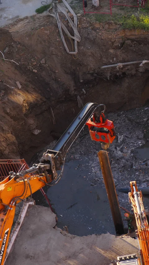 Excavator vibratory hammer driving sheet pile at sewer collector repair site Vídeo Stock 346356006
