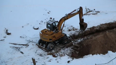 Excavator in winter digging a trench Video stock 87449219