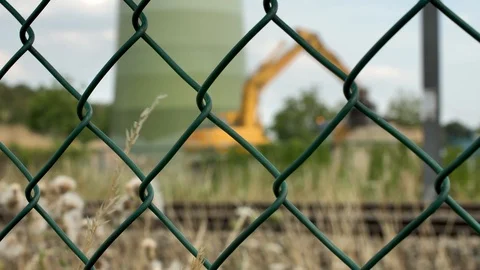 Excavator at work behind fence Stock Footage 93341315
