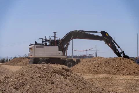 Excavator Working At Construction Site With Large Piles Of Soil Stock Photos