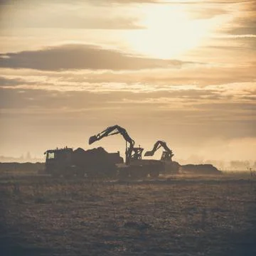 Excavator working on construction site, loading dump track. Foto stock