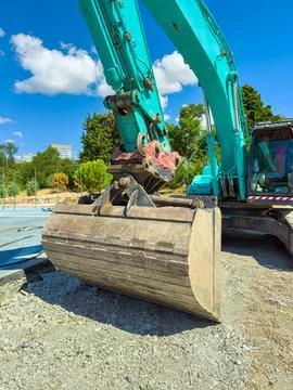 An excavator is working on a construction site, moving large amounts of dirt  Stock Photos