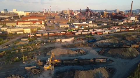Excavator Working Glowing Slag with Flare in front of a steelworks Stock Footage 342956477