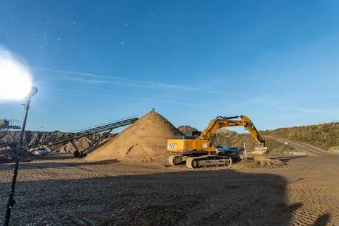 Excavator working on a sandpit at a construction site. Stock Photos