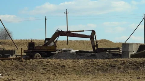 Excavator works on construction site in open field under blue sky at midday Stock-Footage 332015328