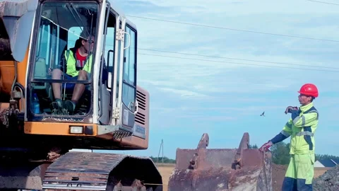 Excavator works on construction site with operator inside cab. Heavy machinery Stock Footage 332559926