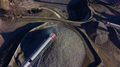 Excavators and conveyor belts work together at a gravel pit under bright Stock Footage 332098428