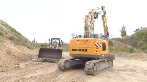 Excavators and wheel loaders drive past each other Stock Footage 229795231