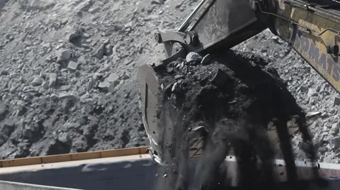 Excavator's bucket unloads coal to dump truck Stock Footage 45797166
