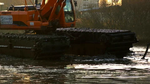 Excavators cleans and deepens the river bed at sunset. Stock Footage 98686892
