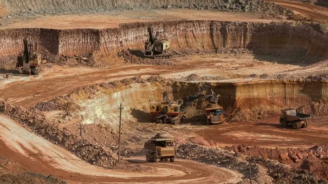 Excavators load ore into dump-trucks. This area has been mined for buaxite Video stock 75043030