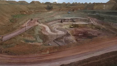 Excavators load ore into dump-trucks. This area has been mined for buaxite Stock Footage 75384161