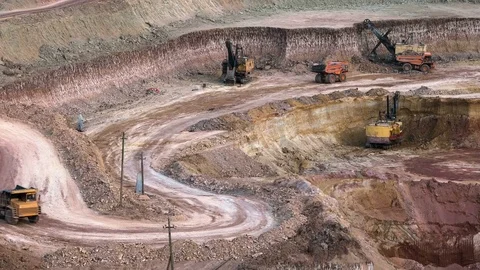 Excavators load ore into dump-trucks. This area has been mined for buaxite Video stock 75462119