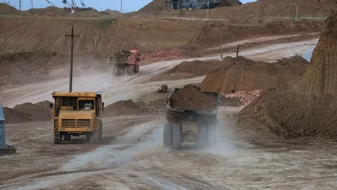 Excavators load ore into dump-trucks. This area has been mined for buaxite Stock Footage 75578694