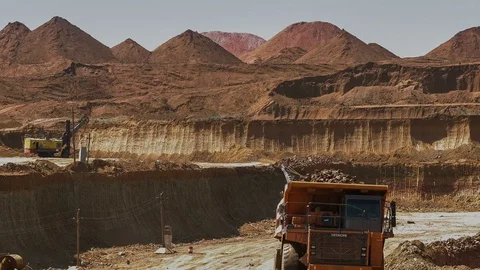 Excavators load ore into dump-trucks. This area has been mined for buaxite 動画素材 75583406