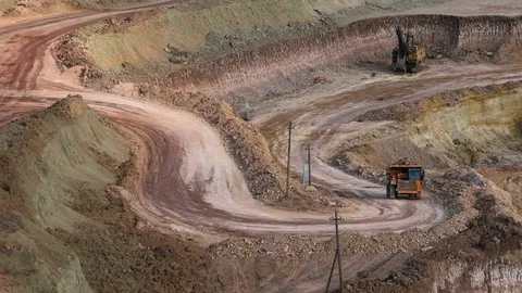 Excavators load ore into dump-trucks. This area has been mined for buaxite Stock Footage 75585621