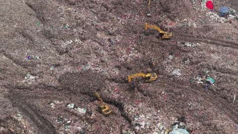 Excavators moving tons of garbage in bantar gebang landfill Stock Footage 327820317
