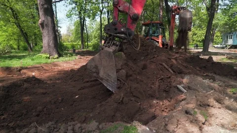 Excavators scooping ground at construction site, roadworks concept. Stock Footage 76877426